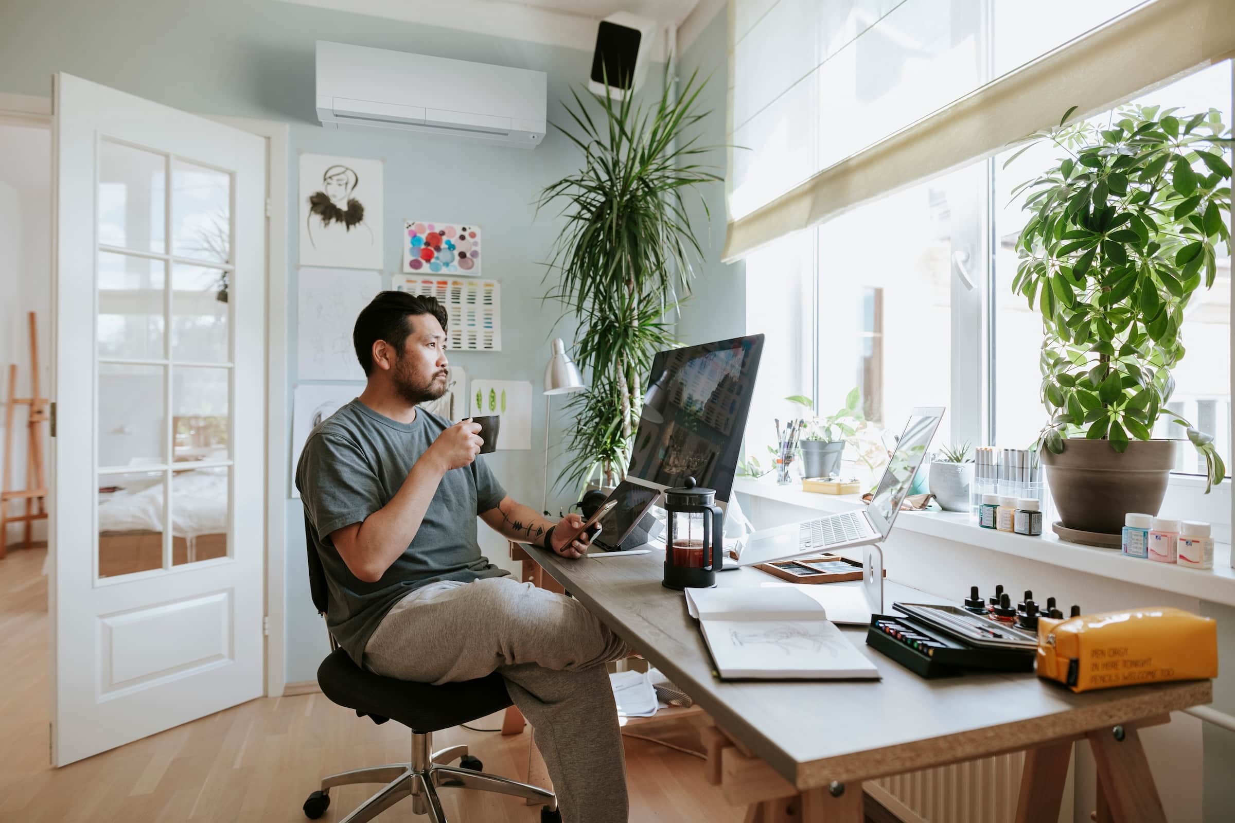 Person working from their home office with a ductless heat pump installed on the wall behind them