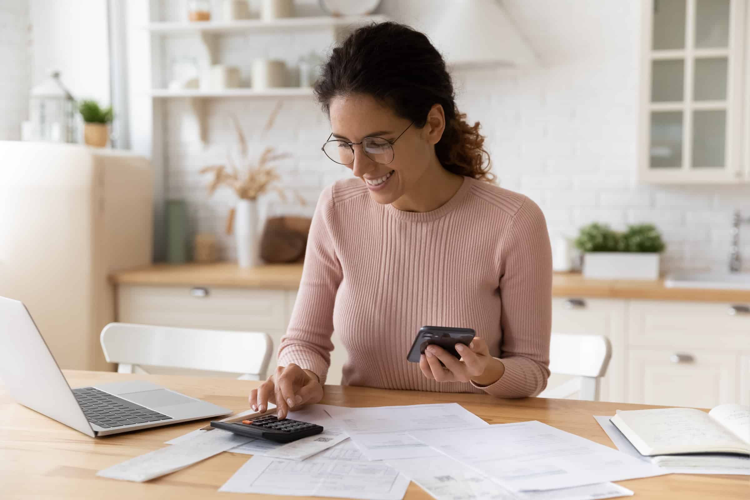 Woman using calculator at a desk