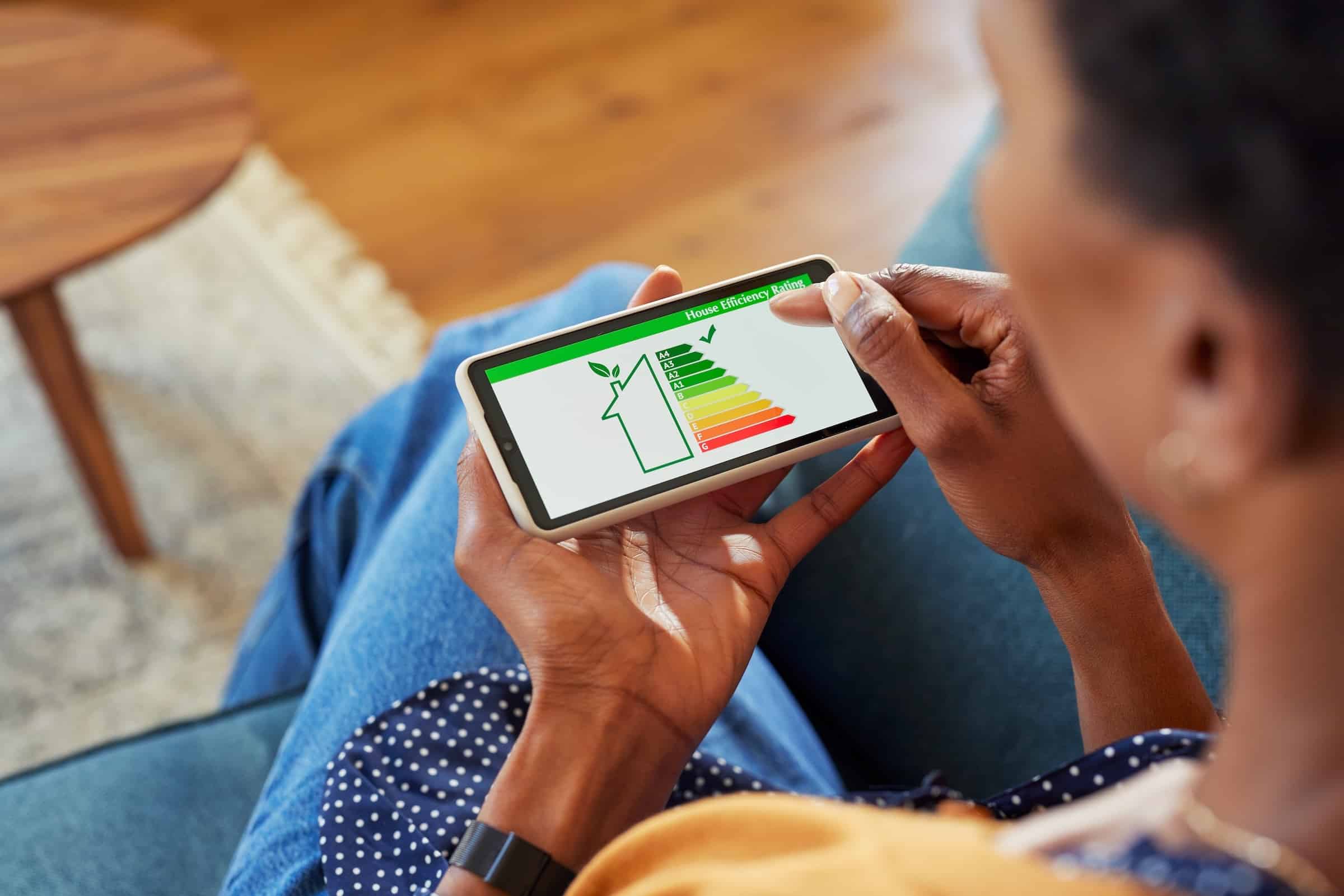 Woman looking at the Energy Efficiency Ratings of her house on her smartphone.