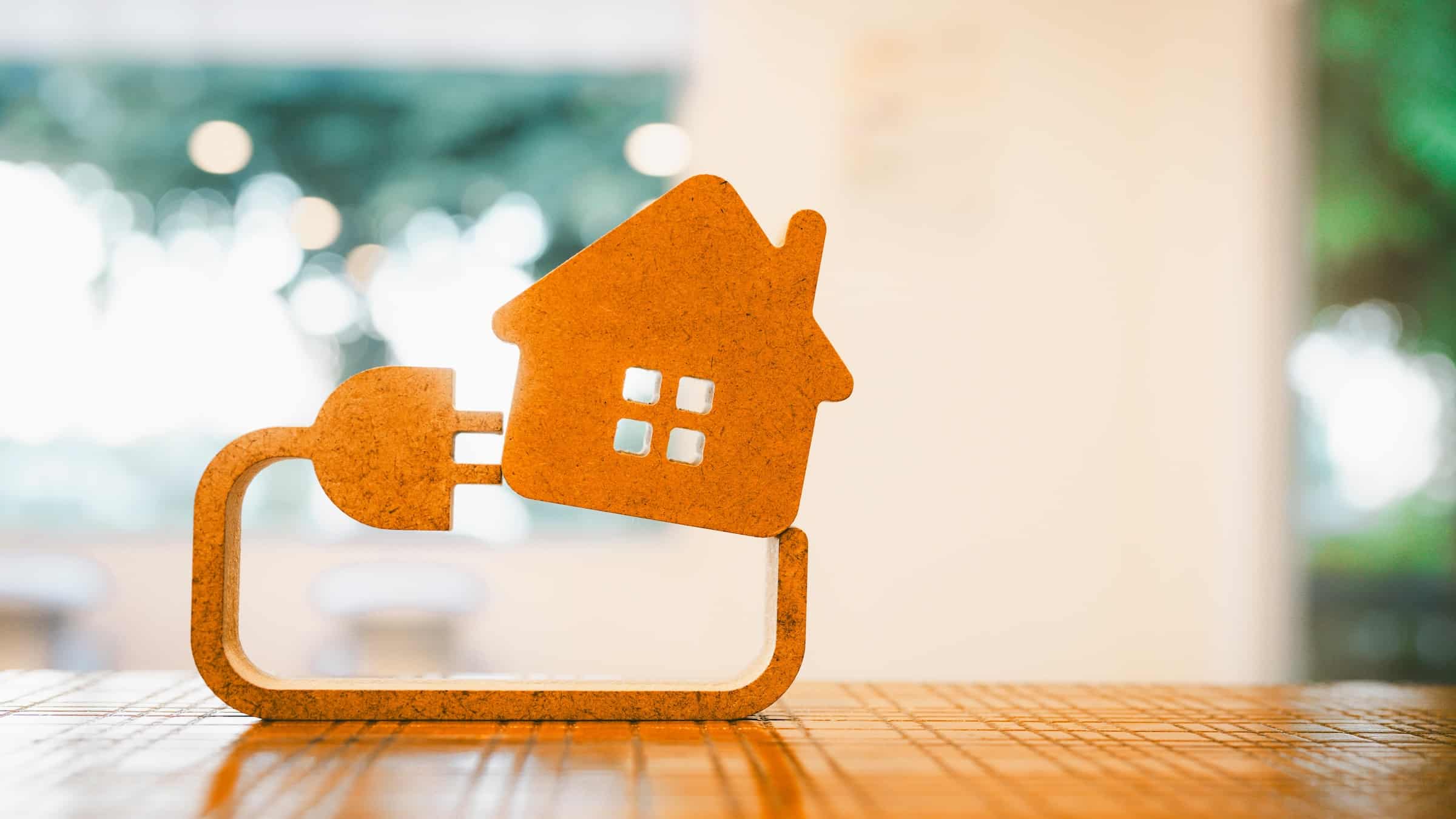 Orange cut-out of a house and an electrical plug.